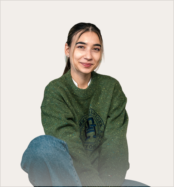 Young woman smiling in a green sweater, representing the creative team at Kreative Angle, a Calgary-based digital marketing agency focused on tailored business solutions.